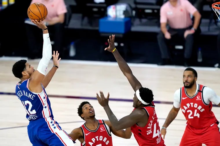Philadelphia 76ers' Tobias Harris, left, goes up for a shot against Toronto Raptors', from left, Kyle Lowry, Pascal Siakam and Norman Powell during the second half of an NBA basketball game Wednesday, Aug. 12, 2020 in Lake Buena Vista, Fla. (AP Photo/Ashley Landis, Pool)