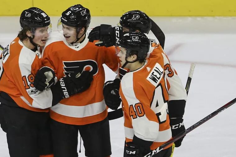 Travis Sanheim, center celebrates with teammates after scoring his first NHL goal in the Flyers’ 2-1 win over Buffalo on Thursday.