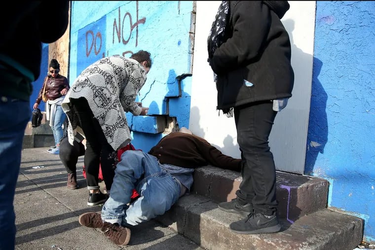 Workers from Prevention Point prepare to give a life-saving dose of Narcan to an unidentified man who was overdosing on Cambria Street off of Kensington Avenue on Wednesday.