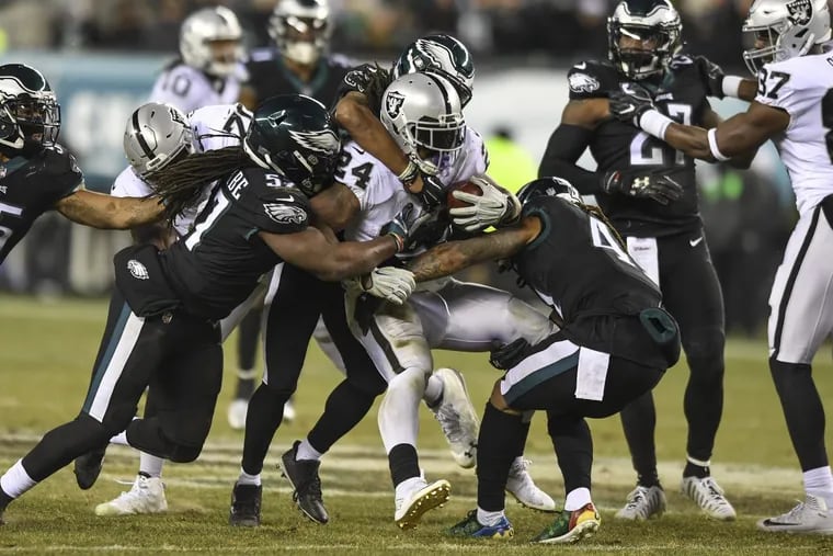 Oakland Raiders running back Marshawn Lynch is gang tackled by Eagles linebacker Dannell Ellerbe (left) saftery Rodney McLeod (center) and cornerback Ronald Darby after a 3-yard gain in the 2nd quarter of the game at Lincoln Financial Field December 25, 2017. CLEM MURRAY / Staff Photographer