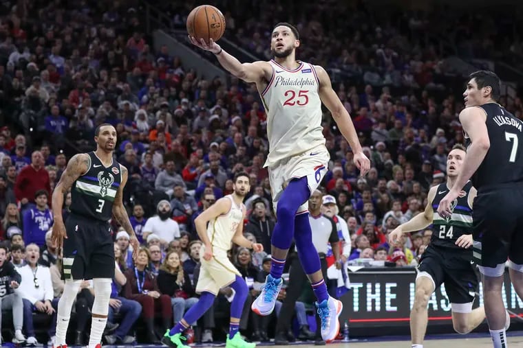 Ben Simmons makes a layup in the third quarter of a game past the Milwaukee Bucks' Ersan Ilyasova (7), Pat Connaughton (24) and George Hill (3) at the Wells Fargo Center on Christmas. The NBA is expected to return in campus-like atmospheres in Las Vegas and Disney World, according to Bucks co-owner Marc  Lasry.