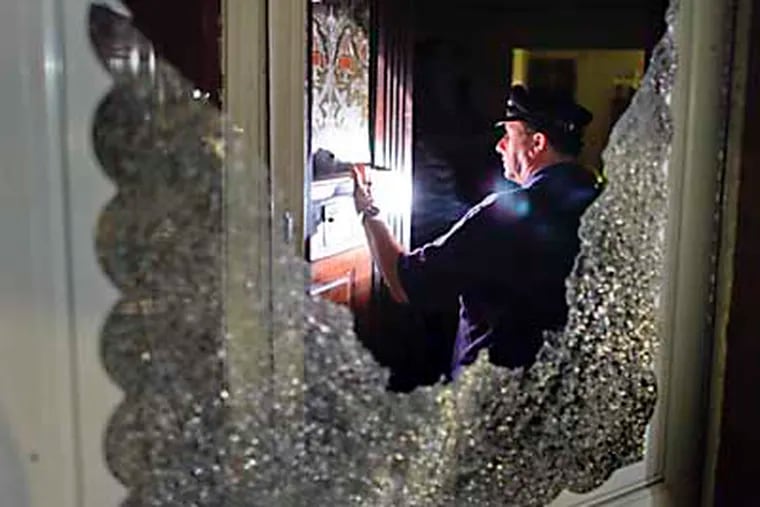 Investigators search for a stray bullet as ballistic evidence after a two year-old was shot in the stomach on the 4600 block of north 12th Street in the Logan section of Philadelphia around 9:30 p.m., Saturday, June 16, 2012. (For the Daily News / Joseph Kaczmarek)