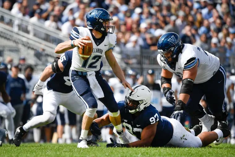 Villanova quarterback Daniel Smith tripped up by Penn State defensive tackle PJ Mustipher in the second quarter.