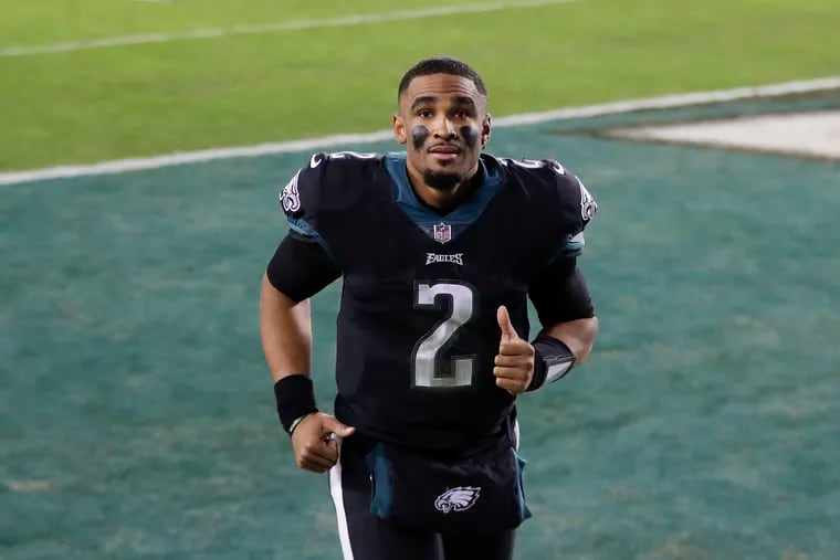Eagles quarterback Jalen Hurts gives a thumbs-up as he runs off the field after the win over the Saints.