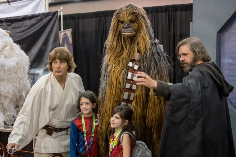 Two kids pose with Star Wars cosplayers dressed (left to right) as a young Luke Skywalker, Chewbacca and an older Luke Skywalker on the show floor at the inaugural Keystone Comic Con, held at the Pennsylvania Convention Center from Sept. 14-16, 2018.