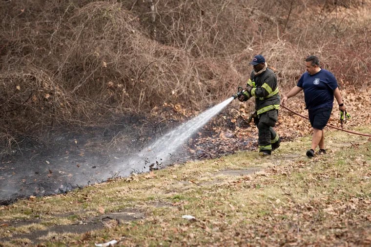 Philadelphia Fire Department firefighters work to extinguish a small brush fire off Sweetbriar Lane in Fairmount Park in March. Some brush fires were reported Saturday as exceptional dryness persisted.