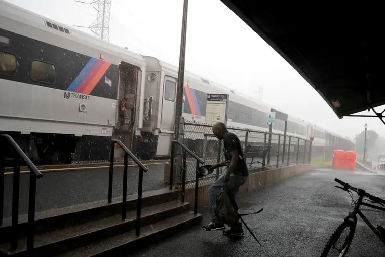 A man walks toward a New Jersey Transit train during heavy downpour at the Bound Brook Station, in Bound Brook, N.J., in 2018.