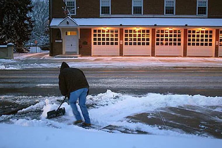 Joe Armstrong shovels the sidewalk at Kings Highway and Haddon Avenue in Haddonfield early yesterday. (Tom Gralish/Staff Photographer)