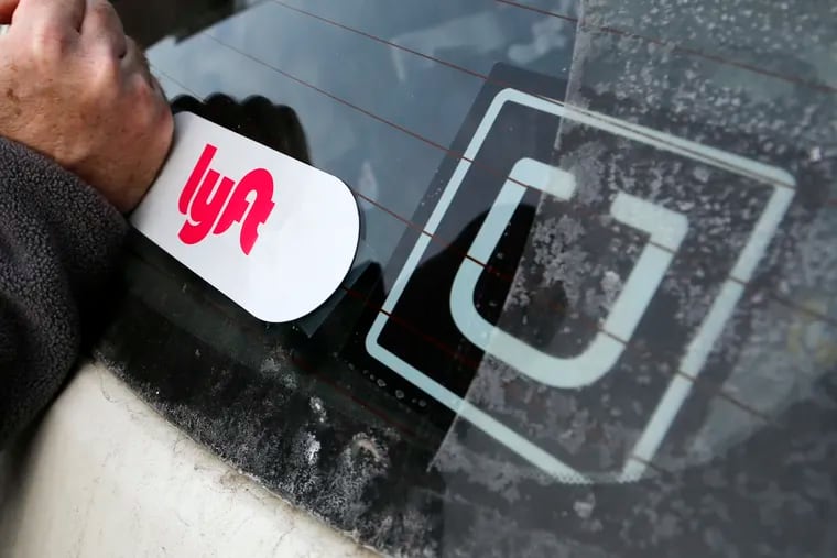 A Lyft logo is installed on a Lyft driver's car next to an Uber sticker in Pittsburgh in this 2018 file photo. Lyft's "2020 Economic Impact Report" shed light on how the service is working in Philadelphia.