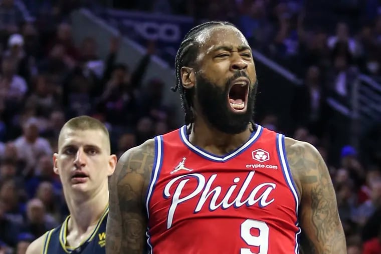 The Sixers' DeAndre Jordan celebrating his dunk over the Nuggets' Nikola Jokic during a game at the Wells Fargo Center on Monday.