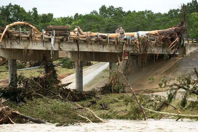 A huge tree rests on the Highway 12 bridge over Texas' Blanco River in Wimberly, a community that is part of a fast-growing corridor between Austin and San Antonio.