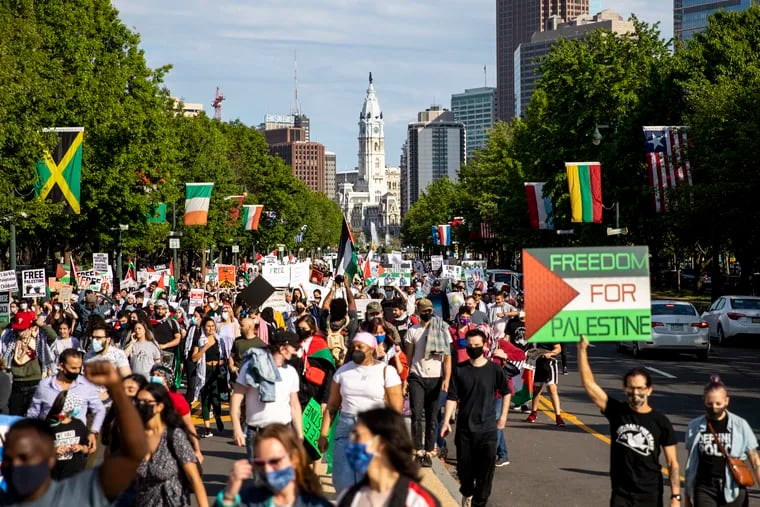 People march on the streets towards the Art Museum steps to protest for peace and justice to free Palestine on Saturday, May 15, 2021.