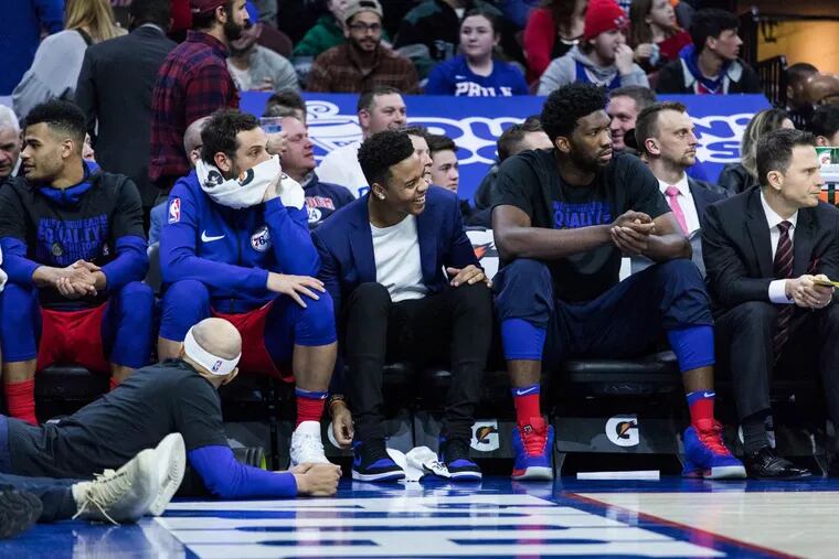 Sixers guard Markelle Fultz sitting on the bench between teammates Marco Belinelli (left), Joel Embiid (right) during the second half of the Sixers’ victory over the Heat at the Wells Fargo Center on Wednesday.