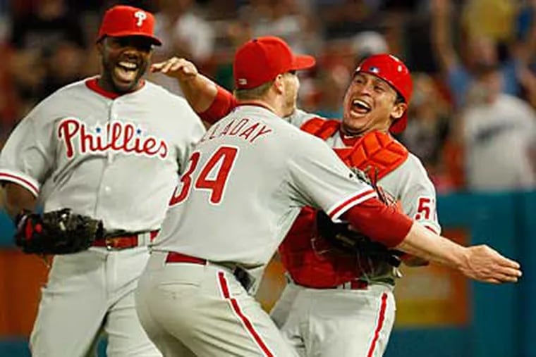 Roy Halladay celebrates the last out of his perfect game with catcher Carlos Ruiz and first baseman Ryan Howard.