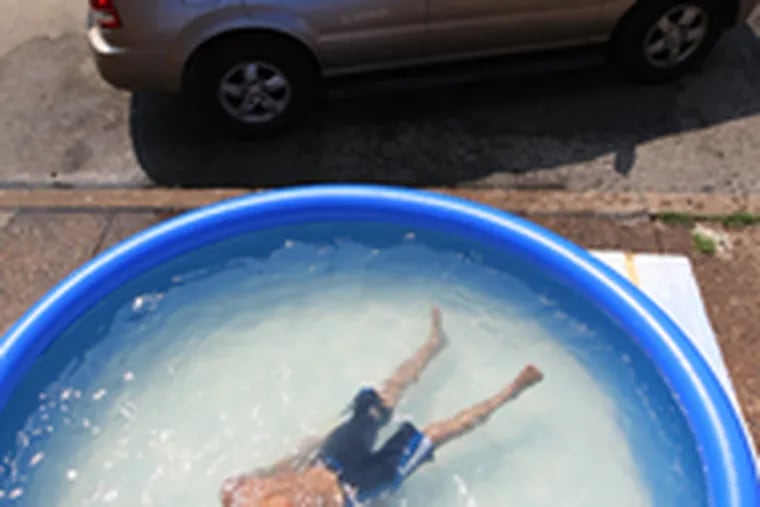 Dennis Kurinskas, 8, floats in a South Second Street pool, which has beena big hit since it was put out Sunday.