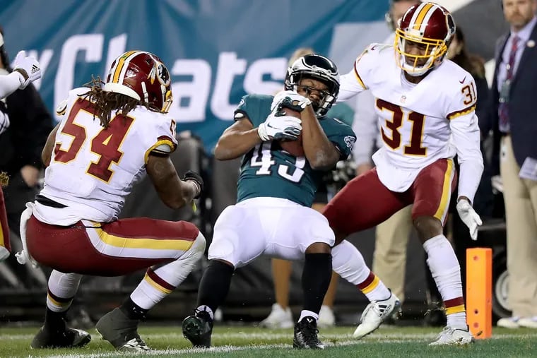 Darren Sproles scores in front of Washington's Mason Foster (left) and Fabian Moreau during the second quarter.