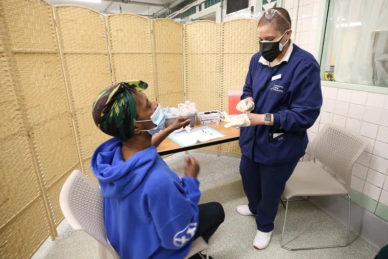 Community College of Philadelphia nursing student Tiffany Marquez (right) prepares to give Michelle Bernard, 57, the COVID-19 vaccine at the Hub of Hope in Philadelphia, Pa. on April 6, 2021. Hub of Hope in the Suburban Station concourse is running a vaccination clinic for those who have experienced homelessness. .