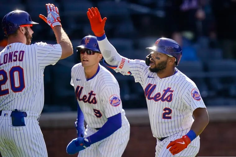 The  Mets' Pete Alonso celebrates with Brandon Nimmo (9) and Dominic Smith after Smith hit a two-run home run during the first inning of Game 1.