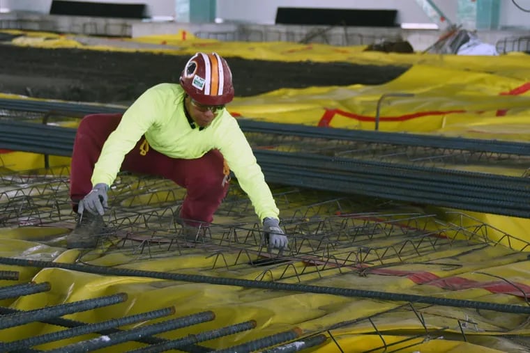 Camden resident Aisha David helps set sections of reinforcing material where a concrete slab will be poured.