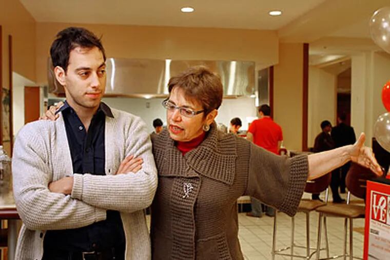 Laura Fattal, mother of Josh Fattal who has been held by Iran since July 2009, puts her arm around her son, Alex, and extends her empty arm while saying there's an empty space where Josh should be. She was raising funds for his return at the Bellevue Food Court in Philadelphia on Friday afternoon. (Laurence Kesterson / Staff Photographer)