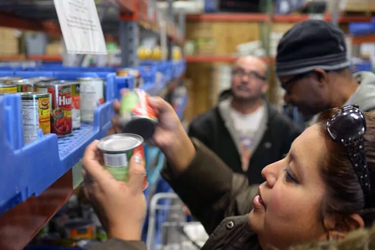Karla Mercado and husband Jose (rear) select food with help from Craig Shawell (center) at the Community Food Bank of New Jersey.