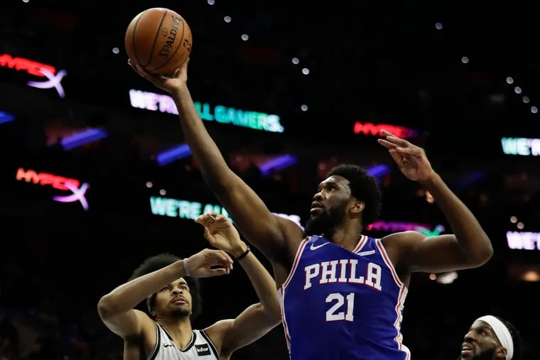 Sixers center Joel Embiid drives to the basket against Nets center Jarrett Allen (left) and forward DeMarre Carroll during the second quarter.