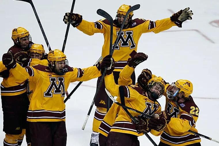 Minnesota's Justin Holl (second right) celebrates his game-winning goal with his teammates late. (Yong Kim/Staff Photographer)