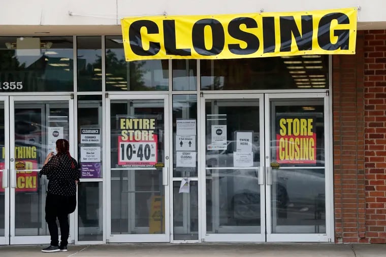 A woman stands outside a closing Gordmans store in St. Charles, Mo. Stage Stores, which owns Gordmans, is closing all its stores and has filed for Chapter 11 bankruptcy.