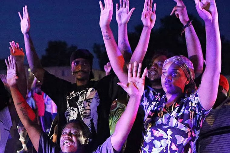 On Aug. 9, 2014, a crowd gathered near the scene where 18-year-old Michael Brown was fatally shot by police in Ferguson, Mo. (AP Photo/St. Louis Post-Dispatch, David Carson, File)