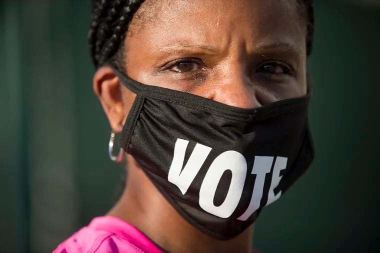 In this Oct. 26 photo, Caprice Clipps wears a "vote" mask as she waits outside the Smoothie King Center in New Orleans for one of the last days of early voting.