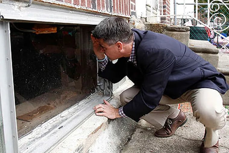 Councilman Bobby Henon , innovator behind the CityHall App, takes it to the street as he inspects a Sally Mae-owned problem property on Algard Street, in Northeast Philadelphia. (David Maialetti / Staff Photographer)