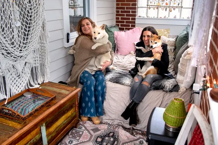 Galit Schwarz (left) and her sister Danielle Yatco with their shiba inus, Bento Box The Fox and Keanu Shives, on the enclosed porch of Schwarz's home in Ventnor City. They are some of the the "new locals" — people settling into Shore houses during the pandemic, they say, for good.