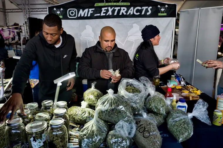 FILE photo shows vendors from MF Extracts counting their intake of cash at their booth at Kushstock 6.5 festival in Adelanto Calif.