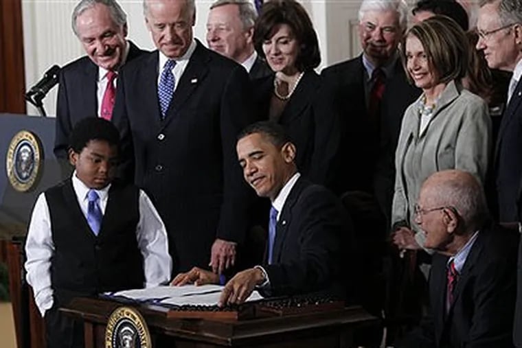 FILE - In this March 23, 2010, file photo, President Barack Obama reaches for a pen to sign the health care bill in the East Room of the White House in Washington. (AP Photo/Charles Dharapak, File)