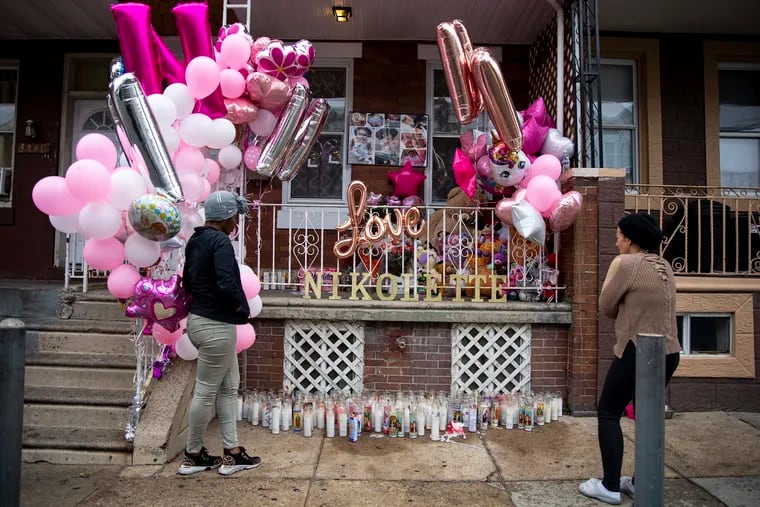 Neighbors Hadiyyah, left, and Angel Roman, right, stand outside the vigil for Nikolette Rivera in Philadelphia on Tuesday, Oct. 22, 2019.