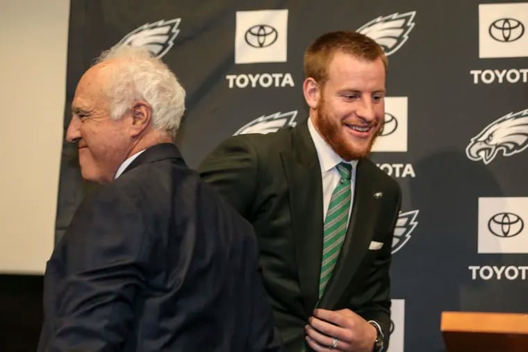 Philadelphia Eagles Quarterback Carson Wentz, right, after getting  a hug from owner Jeffrey Lurie before he talked about his contract extension with the media in Philadelphia, Monday, June 10, 2019