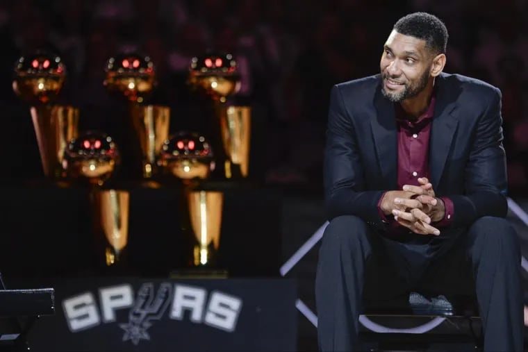 Tim Duncan with the Spurs’ five NBA championship trophies.