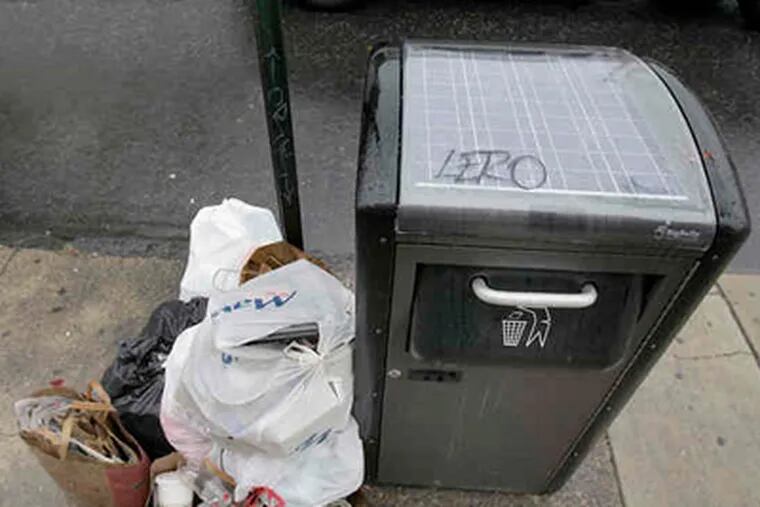 The city streets commissioner says that despite the Big Bellies, like this one near Passyunk Avenue and Bainbridge Street, some people don't bother to insert their trash in them. (David Maialetti / Staff Photographer)