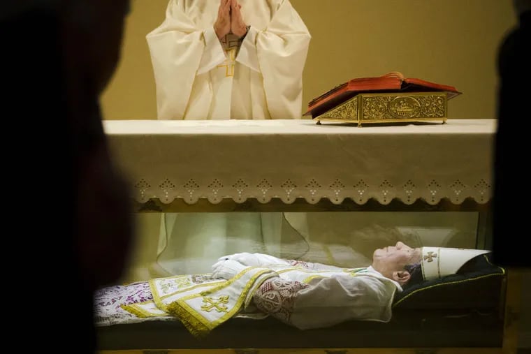 In this Tuesday, May 5, 2015 file photo, the Rev. John McLoughlin, Pastor of Our Mother of Perpetual Help in Ephrata, Pa., prays over the remains of Saint John Neumann at the national shrines of St. John Neumann in Philadelphia. The site is one of the most important Catholic heritage sites in the city, which will host a visit from the Pope in late September 2015. (AP Photo/Matt Rourke)