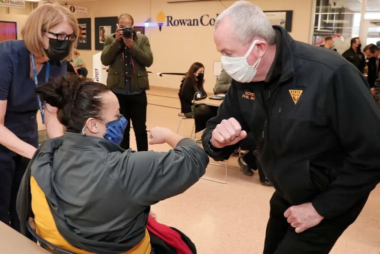 In March, Gov. Phil Murphy gives an elbow bump to Danielle Davis before she receives her first coronavirus vaccine at the Rowan College of South Jersey vaccine mega-site in Deptford.