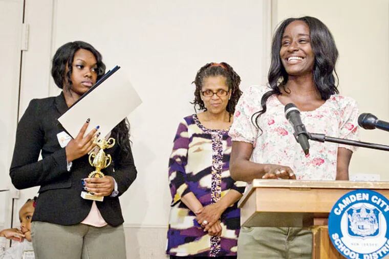 Jazzmine Wilson of Camden High speaks at an awards program at the
Kroc Salvation Army Center for seniors who faced long odds, joined by
classmate Taylor Patterson (left). (CHARLES FOX / Staff Photographer)
