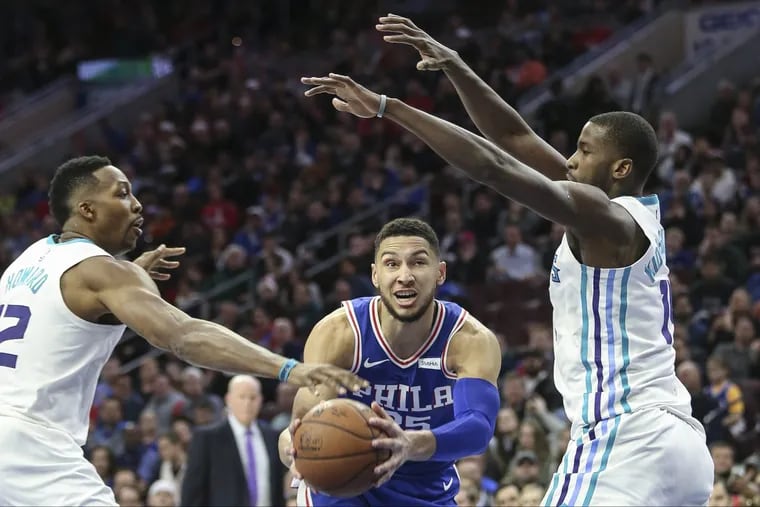 Ben Simmons driving between Hornets Dwight Howard (left) and Michael Kidd-Gilchrist during the fourth quarter.