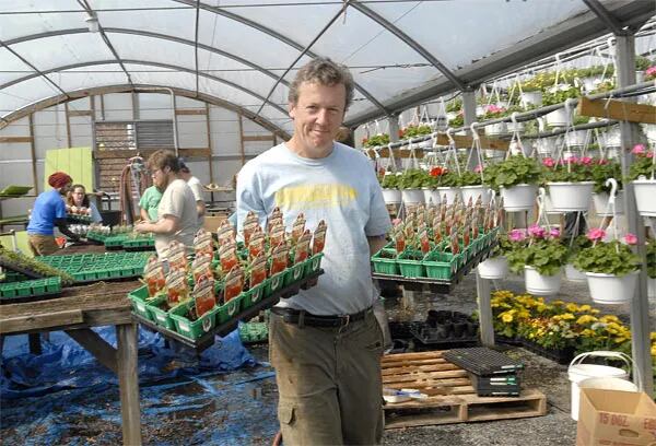 At Greensgrow Farm in Kensington, co-founder Tom Sereduk carries plants. (April Saul / Inquirer)