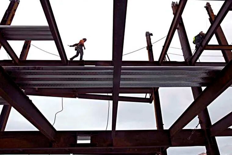 FILE - In this Nov. 29, 2014 file photo, steelworker Nik Pries of Refa Erection walks across decking 23 stories above ground as construction continues on the new Park Avenue West Tower in downtown Portland, Ore. Six years after its financial system nearly sank and nearly that long since the recession ended, the United States seems poised to grow in 2015 at its fastest pace in a decade. Its growth from July through September _ a 5 percent annual rate _ was the swiftest for any quarter since 2003. (AP Photo/The Oregonian, Kristyna Wentz-Graff, File)