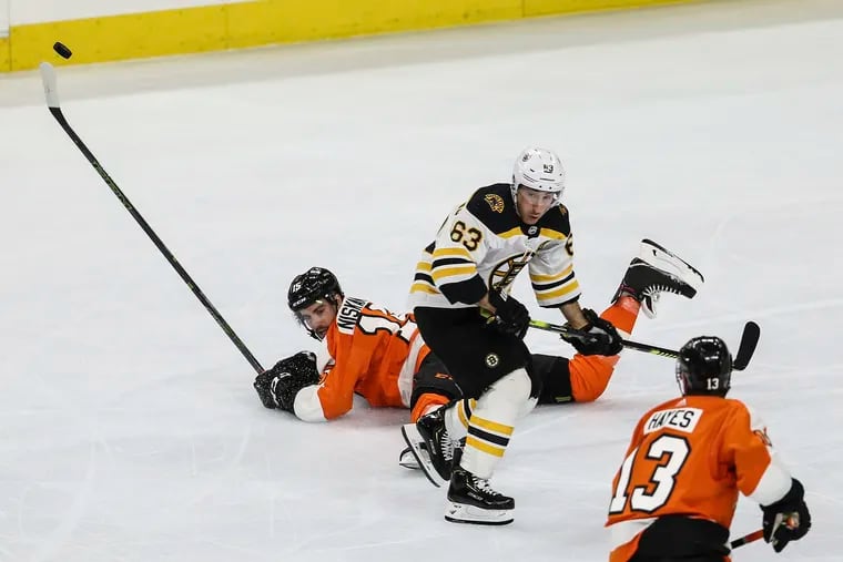 Flyers defenseman Matt Niskanen hits the ice as his teammate Kevin Hayes and the Bruins' Brad Marchand pursue the puck during Boston's 2-0 win Tuesday night.