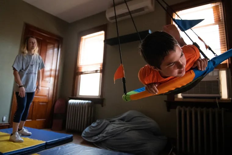 Ronan Strouse, an 11-year-old with autism and other significant behavioral conditions, has regressed without in-person instruction. Here, Ronan flies across his room while being pushed by his personal care aid, Gabby Clauser, at home in East Greenville, Pa.