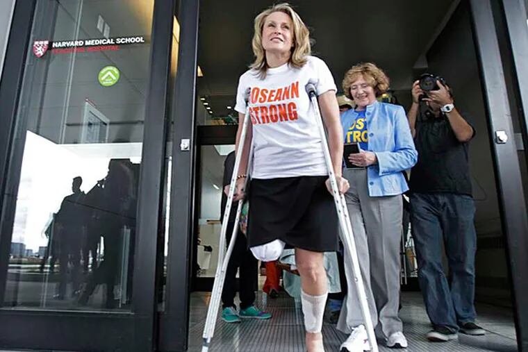 Roseann Sdoia, who lost part of her right leg in the Boston bombings, leaves a rehabilitation hospital. Unlike other cases, victims can receive money without waiving their right to sue. (Charles Krupa/AP)