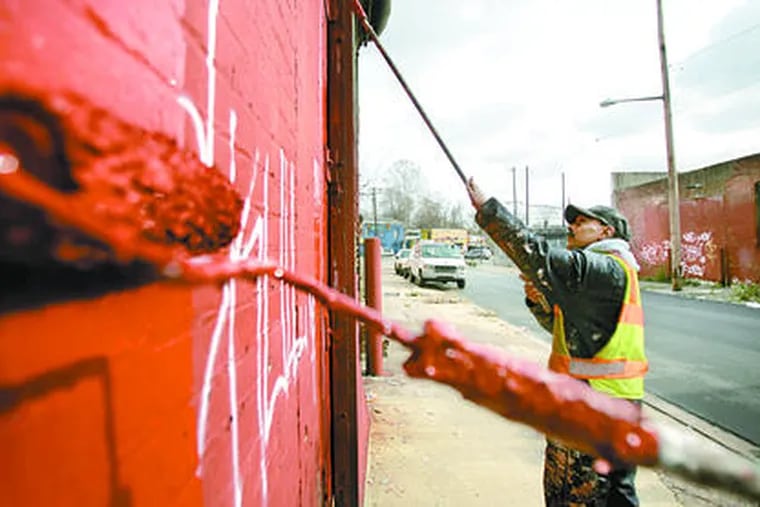 Edguardo Diaz, working on Westmoreland Street, is on one of Philadelphia&#0039;s dozen crews that wipe out graffiti.
