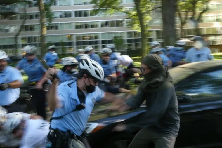 Police clash with protesters early Monday evening near the Benjamin Franklin Parkway.
