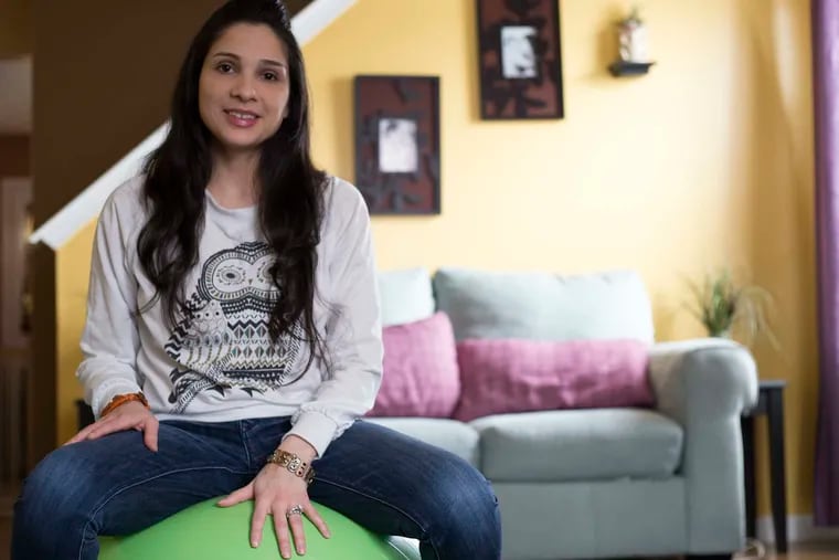 Nyra Zaracho, 31, a doula licensed through the Maternity Care Coalition, sits on a birthing ball in her Juniata Park home in Philadelphia.